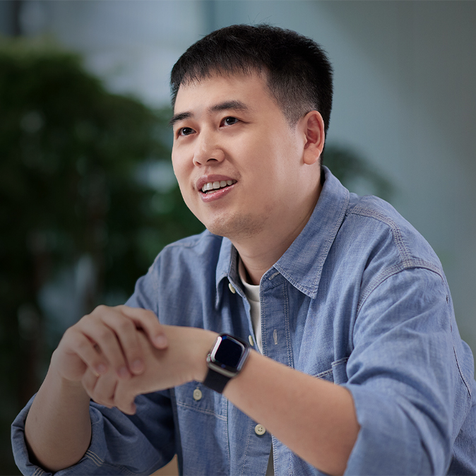  Ken sitter inomhus i ett utrymme som är fullt av växter.