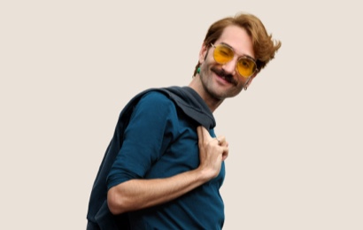 Portrait of a smiling Apple Retail team member with short, dark blond hair and glasses.