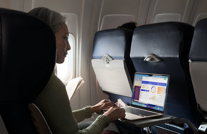 Pessoa a trabalhar no MacBook Air sentada dentro de um avião