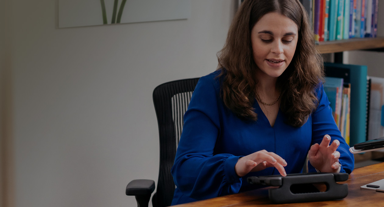 Photo de Jordyn Zimmerman, Apple Distinguished Educator et défenseuse des personnes en situation de handicap, assise à un bureau et tapant sur l’écran d’un iPad