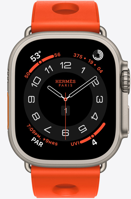 Apple Watch Hermès Ultra 3, Circulaire analog watch face, (hour, minute and second hands, complications: Weather, activity rings, Paris time and UV Index), titanium case, natural color, right side exterior, Digital Crown, raised side button, paired with Scub'H Diving band, orange néon color (bright orange), molded rubber material, circular cutouts centered