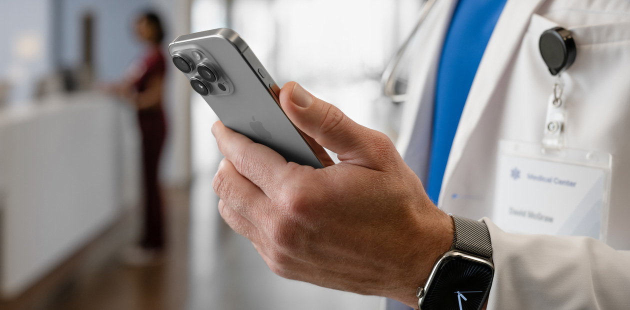 La main d’un médecin tenant un iPhone.