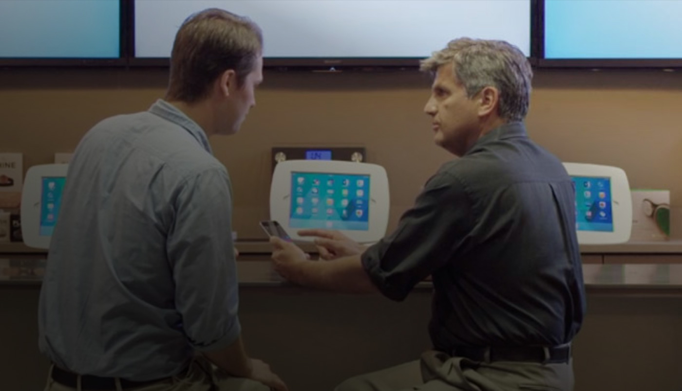 Hai người đàn ông đang ngồi tại O Bar, nhìn vào màn hình iPhone.